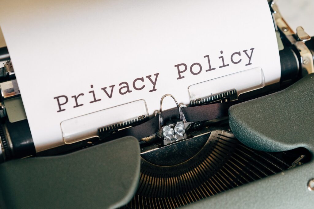 validação de números no WhatsApp - imagem de uma máquina de datilografar com um papel branco nela, onde está escrito "privacy policy"que traduzindo para o português fica "política de privacidade". 