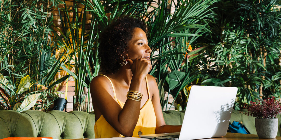 Follow-Up - a imagem que ilustra o tema tem o fundo de um estabelecimento com plantas verdes e um sofá onde tem uma mulher negra sentada, em frente uma mesa com computador, olhando para o lado e fazendo expressão de pensativa.