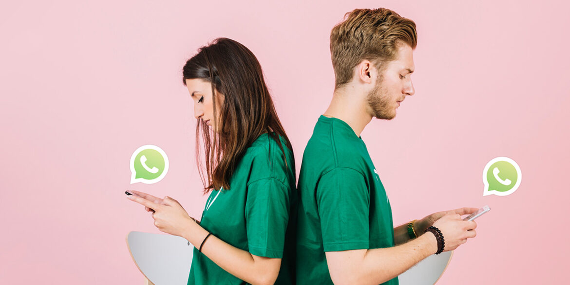 Fila de Atendimento no WhatsApp - A imagem que ilustra o tema tem o fundo rosa e, no meio, tem duas pessoas, um homem e uma mulher. Ambos estão usando camisa verde, segurando um celular e, acima do aparelho, aparece um balão com a logo do WhatsApp dentro dele.