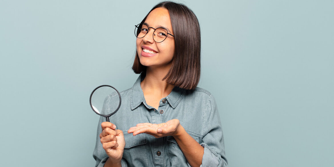 Futuro - a imagem que ilustra o tema tem o fundo cinza e, no meio, uma mulher segurando uma lupa numa mão e apontando para ela com a outra, fazendo expressão de feliz, sorrindo.