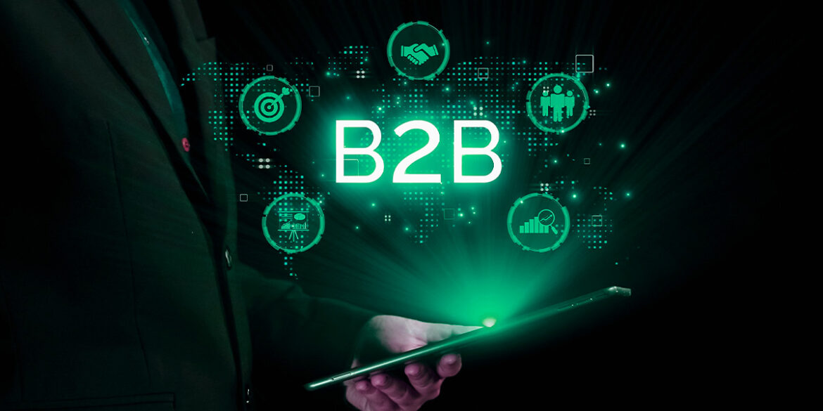 Marketing B2B no WhatsApp - a imagem que ilustra o tema tem o fundo escuro onde aparece uma mão sobreposta segundo um dispositivo móvel que emite uma luz que mostra a palavra B2B e ícones de marketing, parceria, negócios.