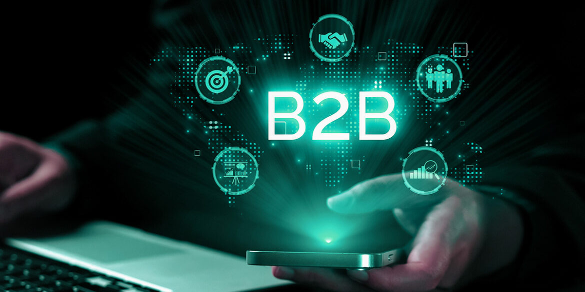 imagem de uma pessoa mexendo no notebook com uma mão e segurando o celular com a outra. simbolizando o marketing b2b