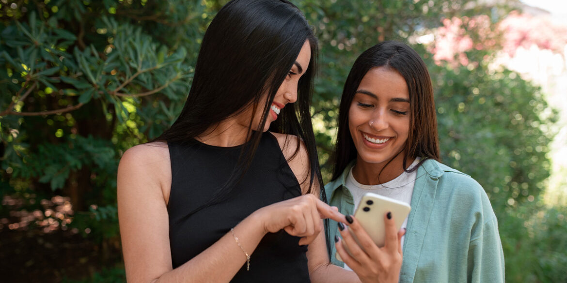 Duas mulheres conversando e mexendo no celular