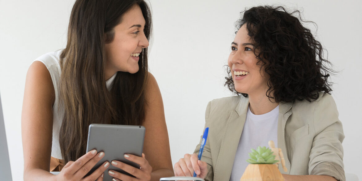 Duas mulheres conversando numa sala de reunião.