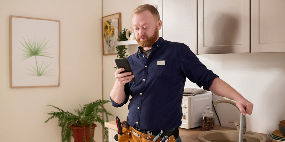 Homem mexendo no celular e falando no whatsApp para serviços de reparos domésticos