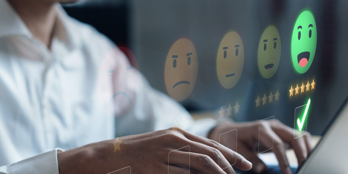 Pessoa mexendo no computador enquanto trabalha, fazendo a análise de de sentimentos dos clientes.