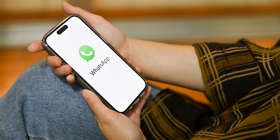 Pessoa com o celular na mão, abrindo o WhatsApp.