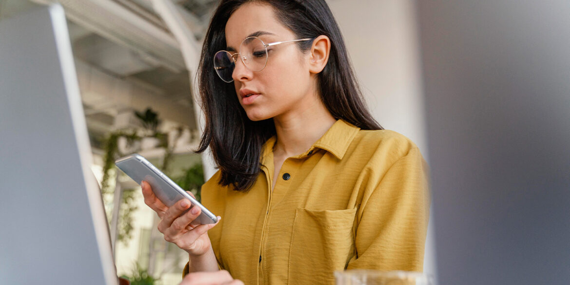 Mulher mexendo no celular, fazendo análise preditiva no WhatsApp